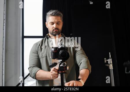 Ein Fachmann stellt eine Kamera auf, um kreative Momente in einem hellen Studio festzuhalten. Stockfoto