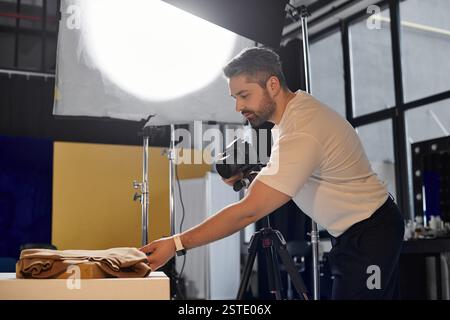 Ein erfahrener Mitarbeiter bereitet die Ausrüstung vor und richtet ein Shooting in einem modernen Studio-Raum ein. Stockfoto