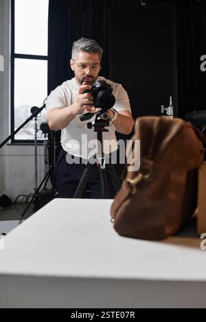 Eine fokussierte Person richtet seine Kamera in einem hellen Studio für ein Kunstprojekt ein. Stockfoto