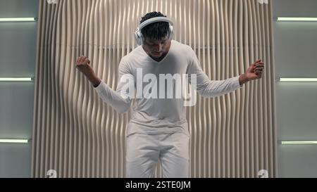 Futurismus Konzept Moderne Unterhaltung Tanzen Bewegung zur Musik unbeschwerte Freiheit Genießen Tanz Afroamerikaner Mann männlicher Mann in Kopfhörern hören Audio Stockfoto