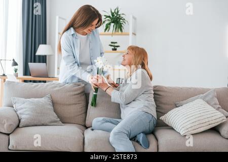 Frohe Muttertag. Seniorin und Tochter sind zu Hause zusammen. Stockfoto