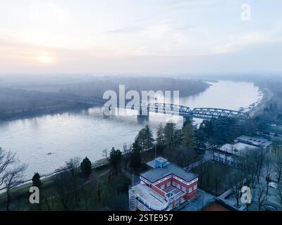Cremona, Italien - 9. Februar 2025 aus der Vogelperspektive auf den Fluss Po in Cremona, Italien, mit einem ruhigen Wintersonnenuntergang mit einer Brücke, die die Ruhe überspannt Stockfoto