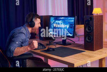 Feiert den Sieg. Online-Streamer, der FPS-Shooter zu Hause spielt. Stockfoto