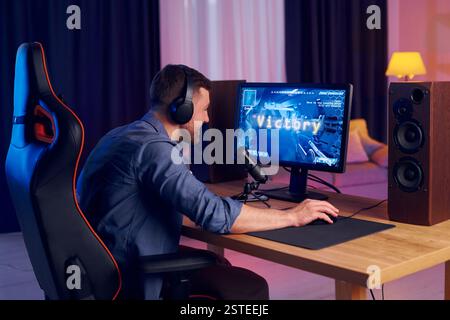 Feiert den Sieg. Online-Streamer, der FPS-Shooter zu Hause spielt. Stockfoto