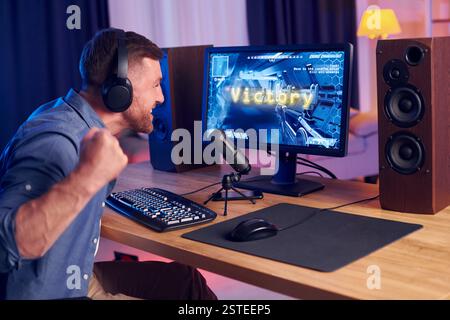 Feiert den Sieg. Online-Streamer, der FPS-Shooter zu Hause spielt. Stockfoto