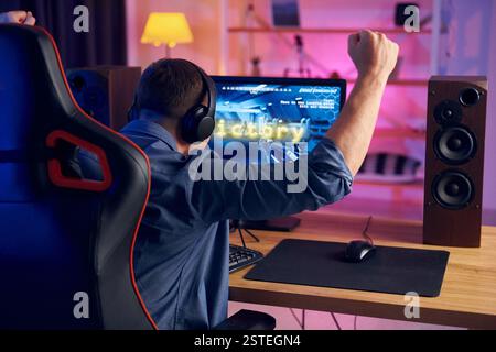 Der Mann gewinnt dieses Spiel. Online-Streamer spielt FPS-Shooter zu Hause. Stockfoto