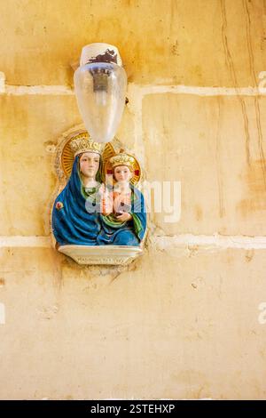 Religiöse Keramiktafel mit Madonna und Kind auf Steinmauer Stockfoto