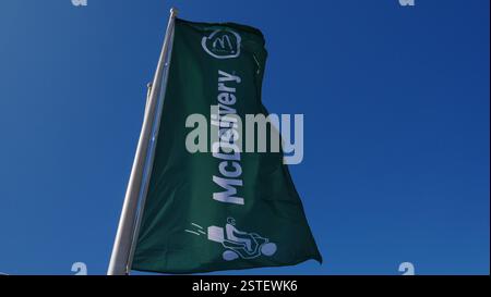 Eine McDelivery Flagge vor einem McDonalds Restaurant am Biosfera Shopping plaza, Puertol del Carmen, Lanzarote. Stockfoto