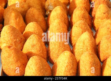 Viele frittierte Reisbällchen namens Arancini oder Arancini, typisch für die Insel Sizilien in Süditalien, werden auf dem lokalen Markt verkauft Stockfoto