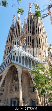 Aus nächster Nähe sehen Sie die komplizierten Türme einer berühmten Basilika mit detaillierten Mauerwerken und Skulpturen. Das Gebäude ist von Grün und umgeben Stockfoto