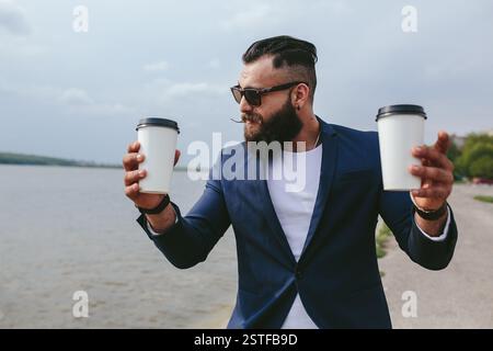 Gut gekleideter Mann trägt Kaffee Stockfoto