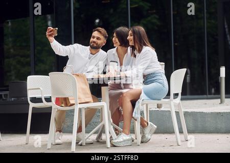 Auf den Stühlen sitzen. Drei Freunde, die zusammen ein tolles Wochenende im Freien verbringen. Stockfoto