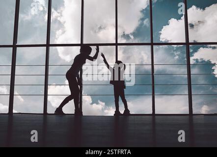 Silhouette von Mutter und Tochter in der Turnhalle Stockfoto