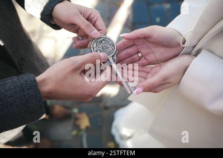 Der Bräutigam gibt der Braut einen Schlüssel Stockfoto