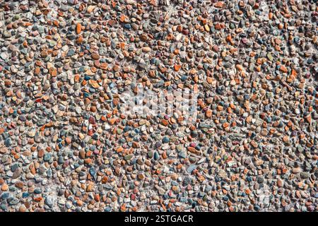 Zerdrückter Kies in Zementwand-verputzter Textur Stockfoto