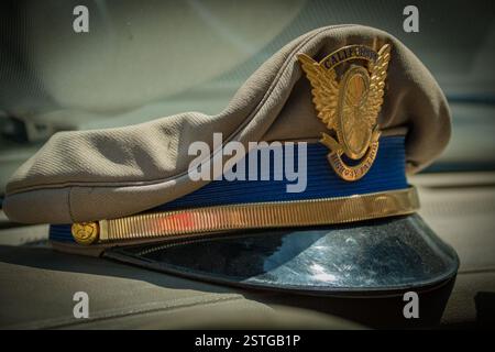 Der alte Hut im Busfahrerstil, der von den California Highway Patrolmen vor dem neueren Hut im Kampagnenstil getragen wurde. Die goldene Kappe trägt das fliegende Rad-Emblem. Stockfoto