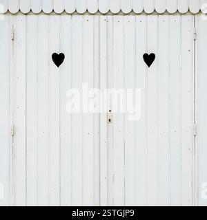 Zwei Herz-geschnitzt auf einer weißen Strandhütte Stockfoto