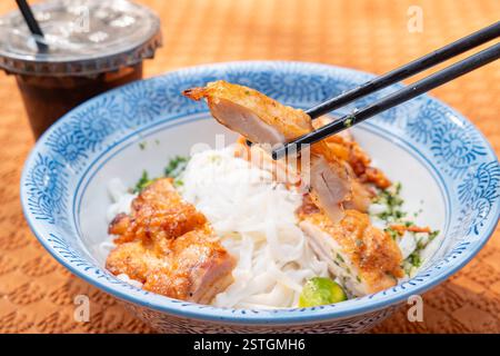 Thailändisches Hühnchen mit Blick auf die Winkel mit gebratenem Ho Fun oder Reisnudeln und einer Tasse Kaffee in horizontaler Zusammensetzung Stockfoto