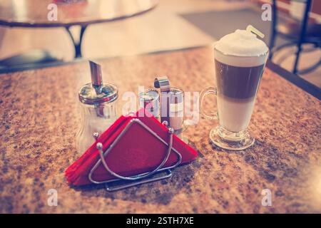 Kaffee Latte in einem Glas auf preshious Bubingo-Woood Tisch, eingefärbte Vintage Töne, flachen DOF, selektiven Fokus Stockfoto