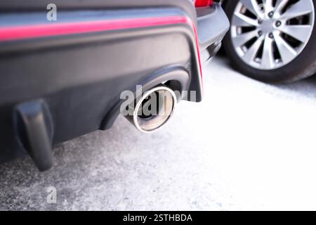 Nahaufnahme des Auspuffrohrs eines Autos , Abgasrohr unter dem hinteren Stoßfänger eines Autos , Konzept für Fahrzeugteile Stockfoto