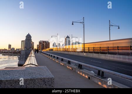 Boston, Massachusetts - 14. Februar 2025 - Menschen laufen zu Fuß, Auto und Zug auf der Longfellow Bridge über den Charles River während des Winters Sonnenuntergang Stockfoto
