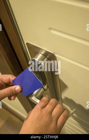 Nahaufnahme einer Hand mit einem blauen Kartenschlüssel an einem Hoteltürschloss, elektronisches Schlüsselschloss, Hotelzimmer, Urlaub auf mallorca, spanien Stockfoto
