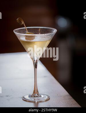 Ein klassisches Martini-Glas mit grüner Olive oben Stockfoto
