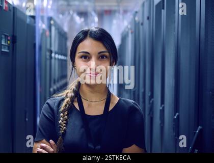 Porträt einer lächelnden Technikerin im Serverraum Stockfoto