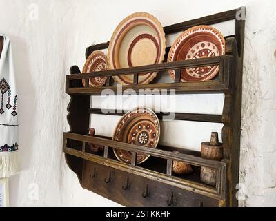 Tonplatten auf einem Vintage-Holzregal mit rustikaler Handwerkskunst in gemütlicher Umgebung. Stockfoto