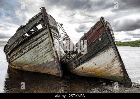 Zwei verlassene Holzfischboote in Salen Sound, Isle of Mull, Innere Hebriden, Schottland. Diese Boote verfallen seit über 50 Jahren im Wasser Stockfoto