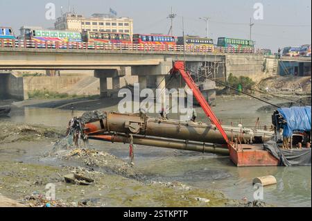 Arbeiter entfernen Kunststoff und andere Ablagerungen aus dem Schleifkopf einer Grabmaschine entlang der verschmutzten Ufer des Karnaphuli River in Chittagong. Müllhaufen haben den Fluss kontaminiert, sich an den Ufern ansammeln und sowohl das Meeresökosystem als auch die menschliche Gesundheit schädigen. Bangladesch. Stockfoto