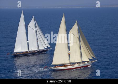 Blick aus der Vogelperspektive auf die eleganten Segelyachten, Meteor und Borkumriff, die in ruhigem blauem Wasser im offenen Meer navigieren Stockfoto