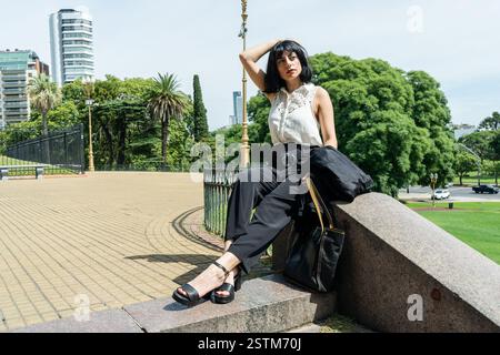 Geschäftsfrau sitzt in einem Park und genießt einen Moment der Ruhe während ihres Arbeitstages in buenos aires Stockfoto