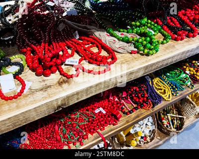 Velykyi Chodachkiv, Ukraine - 18. Februar 2025: Eine Auswahl an lebendigen Perlen und Schmuckstücken, die auf rustikalen Holzregalen angeordnet sind Stockfoto