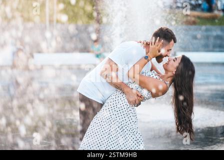Hübscher Kerl und schöne Mädchen küssen Auf dem Hintergrund einer Brunnen Stockfoto