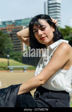 Stilvolle Geschäftsfrau, die sich in einem Stadtpark ausgibt und Selbstvertrauen und Professionalität ausstrahlt Stockfoto