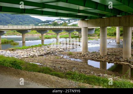 Goesan County, Südkorea - 10. September 2020: Ein Blick auf mehrere Brücken über den Seonghwang Stream, mit Radfahrern in der Ferne und im Wasser Stockfoto