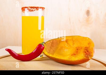 Sommerlicher tropischer mexikanischer kalter Cocktail. Mangonada mit Mango und heißer Chili auf hölzernem Hintergrund mit Kopierraum Stockfoto