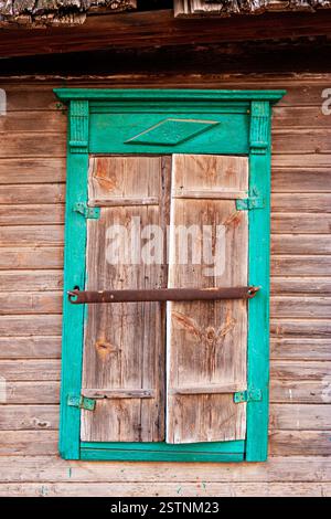 Geschlossene Fensterläden des geschnitzten Fensters eines Holzhauses im alten russischen Stil in Astrachan Stockfoto