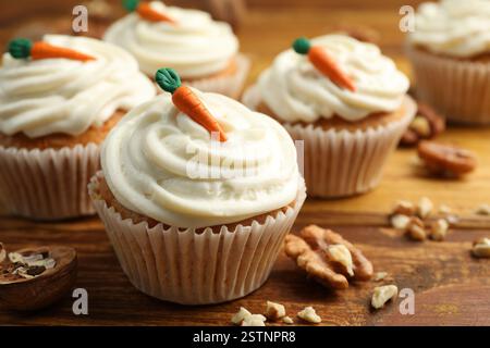 Leckere Karotten-Cupcakes und Walnüsse auf Holztisch, Nahaufnahme Stockfoto