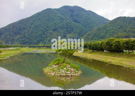 Goesan County, Südkorea - 10. September 2020: Eine kleine, von Bäumen bedeckte Insel liegt im stillen Wasser des Seonghwang Stream nahe Goesan, mit dem Su Stockfoto