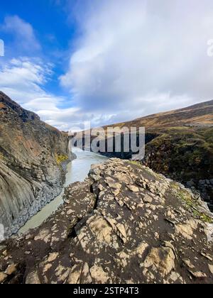 Ein Fluss, der durch eine zerklüftete Schlucht mit steilen Felsformationen fließt, schafft eine ruhige und doch kraftvolle Atmosphäre inmitten der komplizierten Details der Natur Stockfoto
