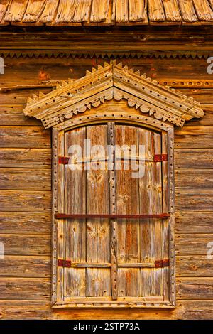 Traditionelles russisches Holzfenster mit geschlossenen Scherben in warmen Tönen Stockfoto