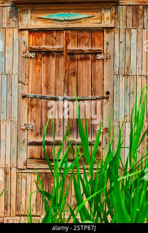Geschlossenes Holzfenster mit Blick auf das Slumhaus, Shanties-Detail Stockfoto