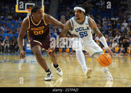 UCLA Bruins Garde Skyy Clark (55) dribbelt den Ball gegen Frank Mitchell (00) der Minnesota Golden Gophers in der zweiten Halbzeit während eines Basketballspiels der NCAA College am Dienstag, den 18. Februar 2025, in Los Angeles. Stockfoto
