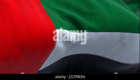 Aus nächster Nähe sehen Sie die Nationalflagge der Vereinigten Arabischen Emirate, die im Wind winkt. Die Emirate sind ein Land in Westasien. Geriffelter Stoff. Strukturierter Backgr Stockfoto