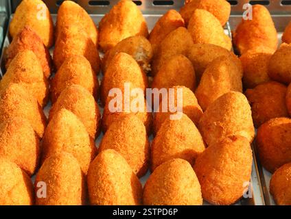 Viele frittierte Reisbällchen genannt Arancini oder Arancini, typisch für die Insel Sizilien in Süditalien, werden auf dem lokalen Markt verkauft Stockfoto