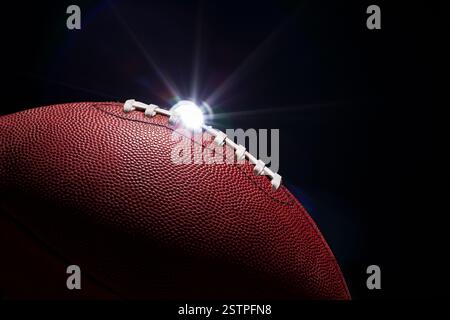Fußball-Nahaufnahme mit dramatischer Beleuchtung und einem Leuchtfeuer auf schwarzem Hintergrund Stockfoto