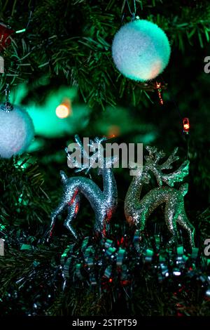 Wunderschön beleuchtete Weihnachtsdekoration in Form eines Rentiers, platziert in einem Weihnachtsbaum, mit leuchtenden Lichtern in hellen Farben. Stockfoto