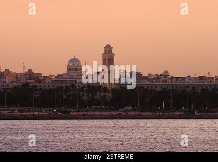 Libyen. Die Skyline von Tripolis in der Abenddämmerung. Kuppel und Minarett der Moschee der World Islamic Call Society. Vom Seehafen aus gesehen. Stockfoto